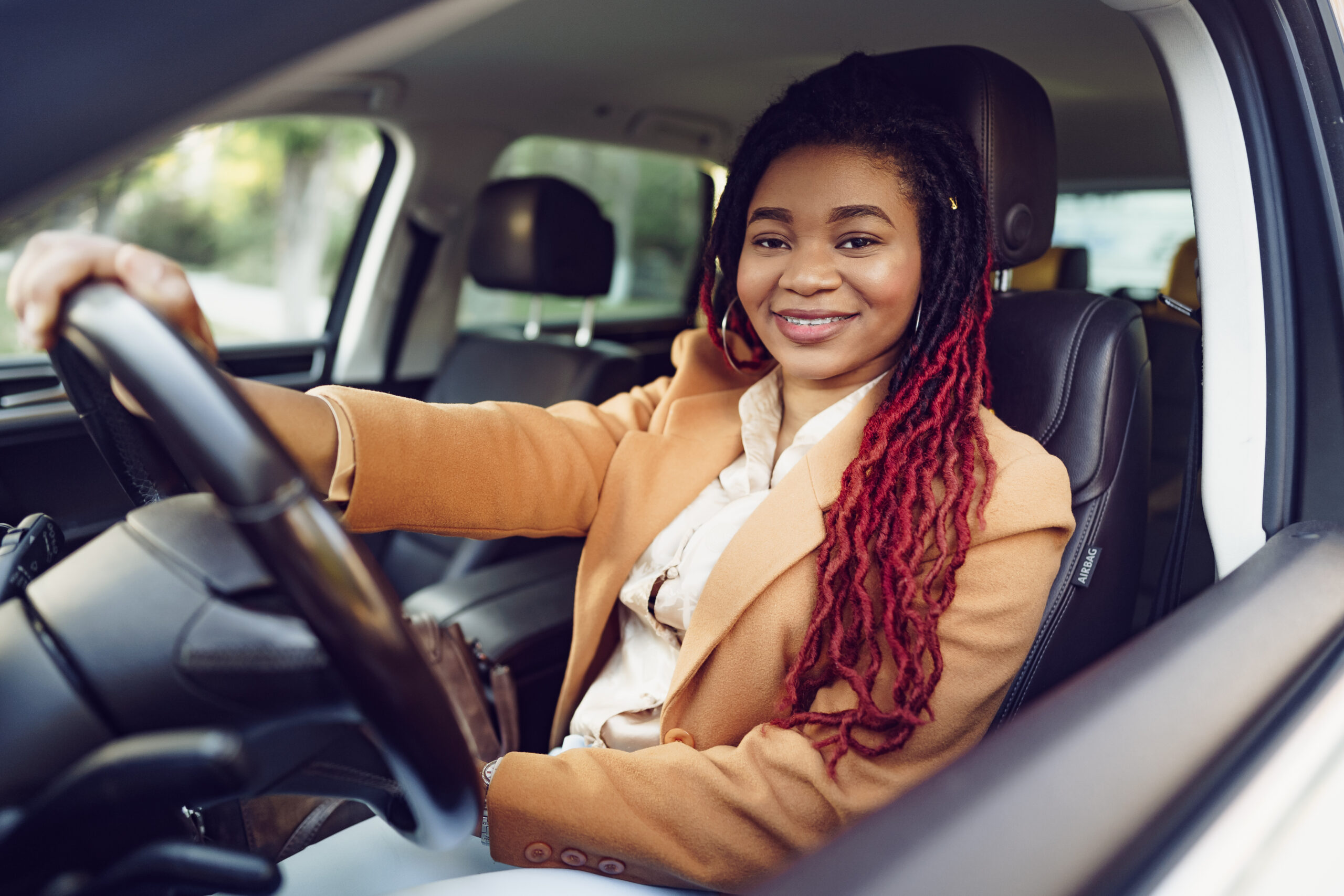 Portrait of positive lady inside the car, close up