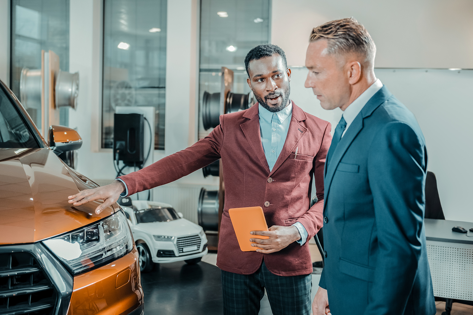 Car dealer helping his client buying a car.